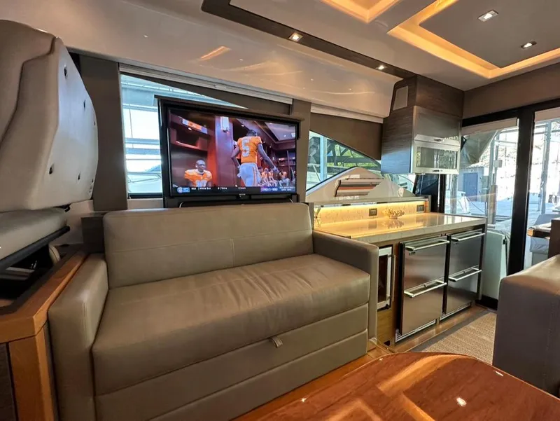 Slide: The Image of Interior of 2019 Tiara Yachts C53 with TV, sofa, and modern kitchen. - 17