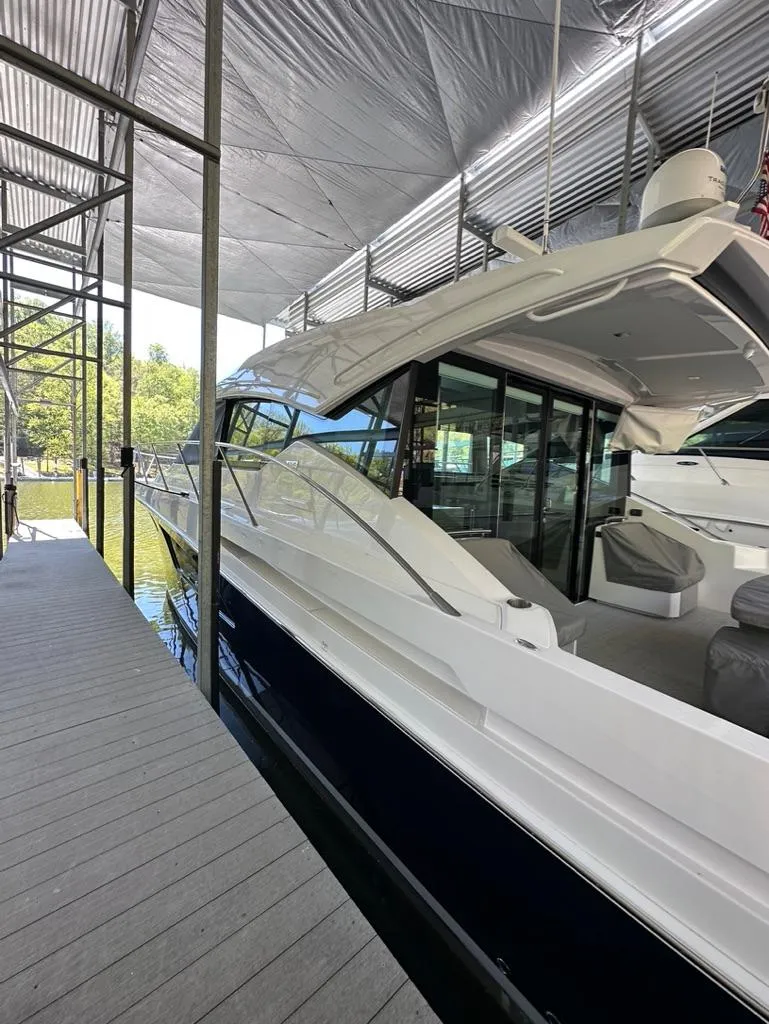 Slide: The Image of 2019 Tiara Yachts C53 docked under a covered marina. - 6