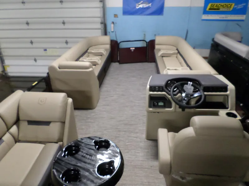 Slide: The Image of 2023 Godfrey Sweetwater 2486SFL pontoon boat interior with beige seating and steering console. - 5