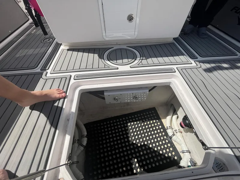 Slide: The Image of Open hatch on 2018 Fountain 34 CC boat deck showing storage compartment. - 10