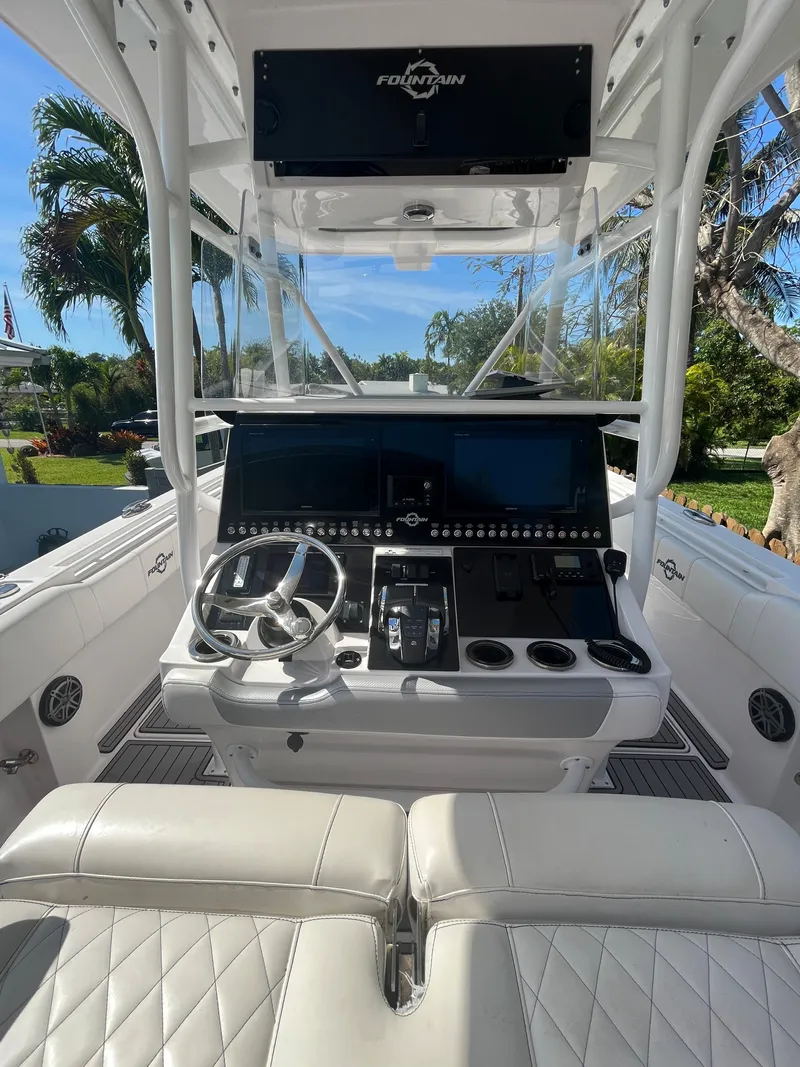 Slide: The Image of 2018 Fountain 34 CC boat cockpit with steering wheel and control panel. - 13