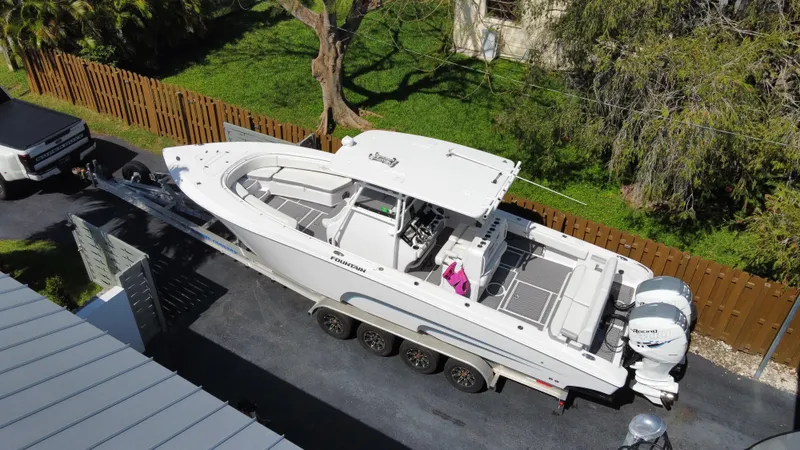 Slide: The Image of 2018 Fountain 34 CC boat on a trailer in a driveway. - 19
