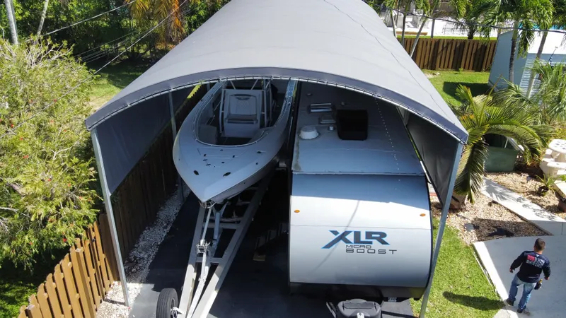 Slide: The Image of 2018 Fountain 34 CC boat and XLR Boost RV under a canopy. - 25