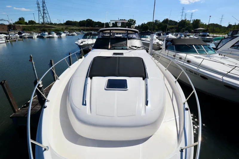 Slide: The Image of 2001 Sea Ray 460 Sundancer yacht docked in a marina, surrounded by other boats. - 10