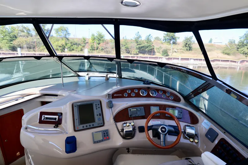 Slide: The Image of Cockpit of 2001 Sea Ray 460 Sundancer yacht with navigation instruments and steering wheel. - 11