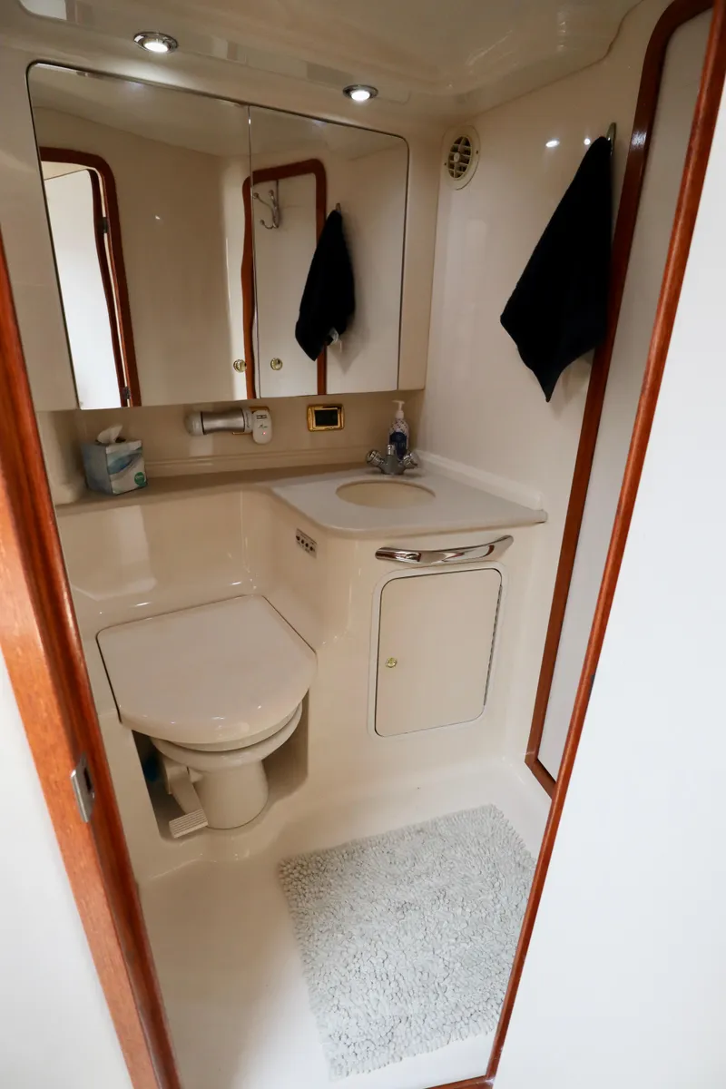 Slide: The Image of Bathroom interior of 2001 Sea Ray 460 Sundancer yacht, featuring sink, toilet, and mirror. - 17