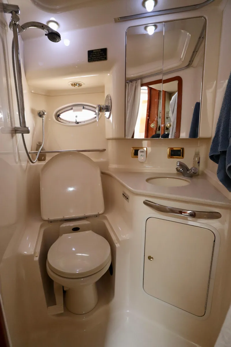Slide: The Image of Bathroom interior of 2001 Sea Ray 460 Sundancer yacht, featuring toilet, sink, and shower. - 21