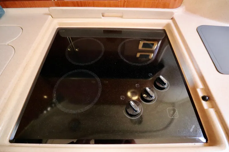 Slide: The Image of Stovetop in 2001 Sea Ray 460 Sundancer yacht kitchen, featuring four burners and control knobs. - 31