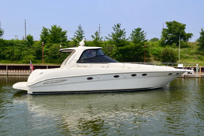 Slide: The Image of 2001 Sea Ray 460 Sundancer yacht on calm water, surrounded by greenery. - 47