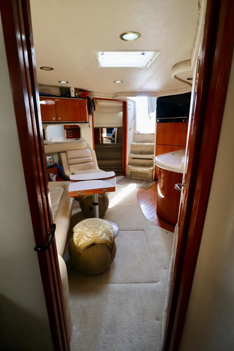 Slide: The Image of Interior of 2001 Sea Ray 460 Sundancer yacht, featuring luxurious seating and elegant wood finishes. - 5