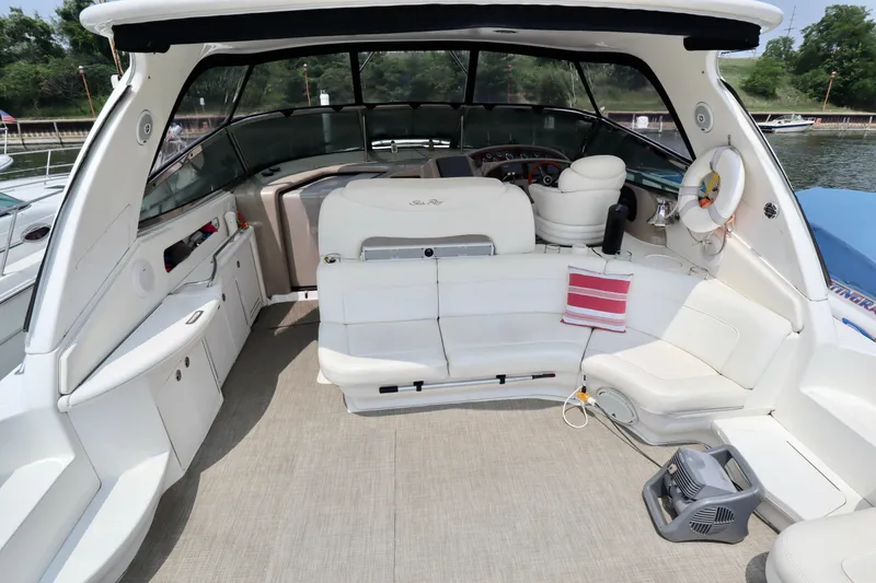 Slide: The Image of 2001 Sea Ray 460 Sundancer yacht interior with white seating and helm, docked by the water. - 8