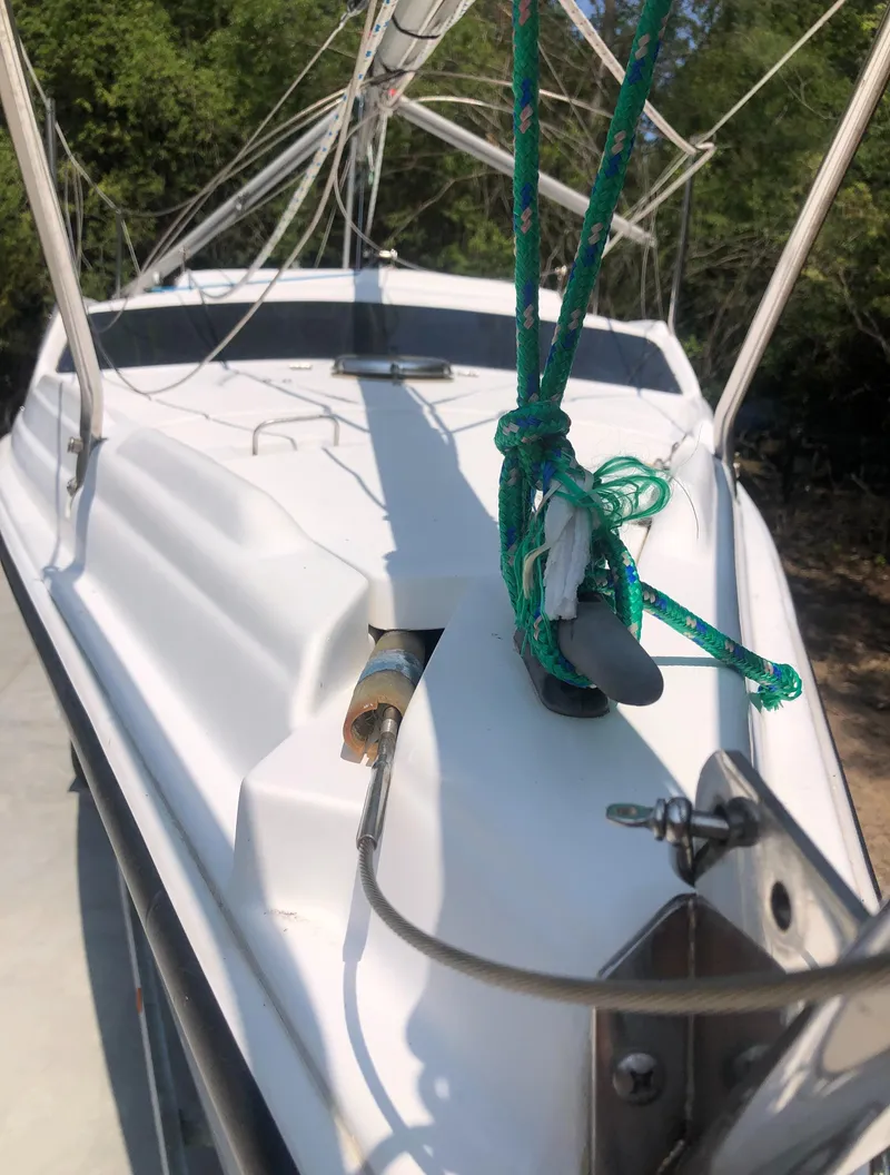 Slide: The Image of 1998 Hunter 240 sailboat deck with green ropes and forest background. - 11