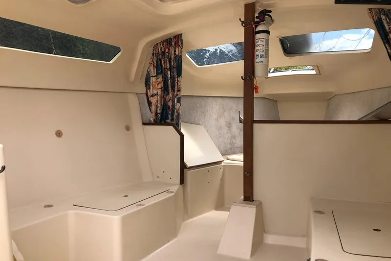 Slide: The Image of Interior of a 1998 Hunter 240 sailboat, featuring seating and windows. - 18
