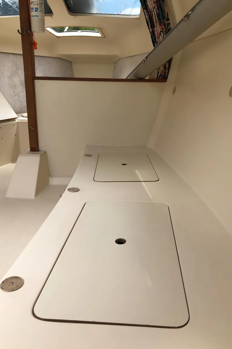 Slide: The Image of Interior of a 1998 Hunter 240 sailboat, featuring storage compartments and skylights. - 19