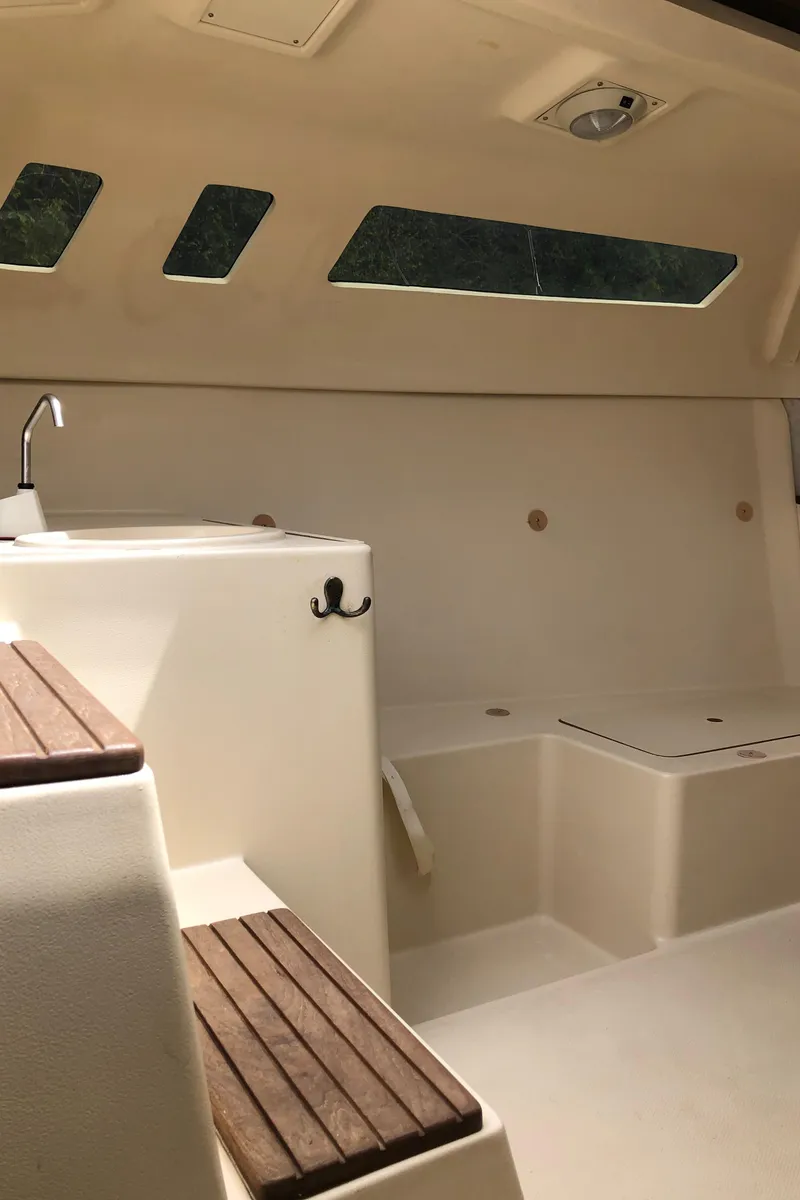 Slide: The Image of Interior of a 1998 Hunter 240 sailboat, featuring seating and windows. - 21