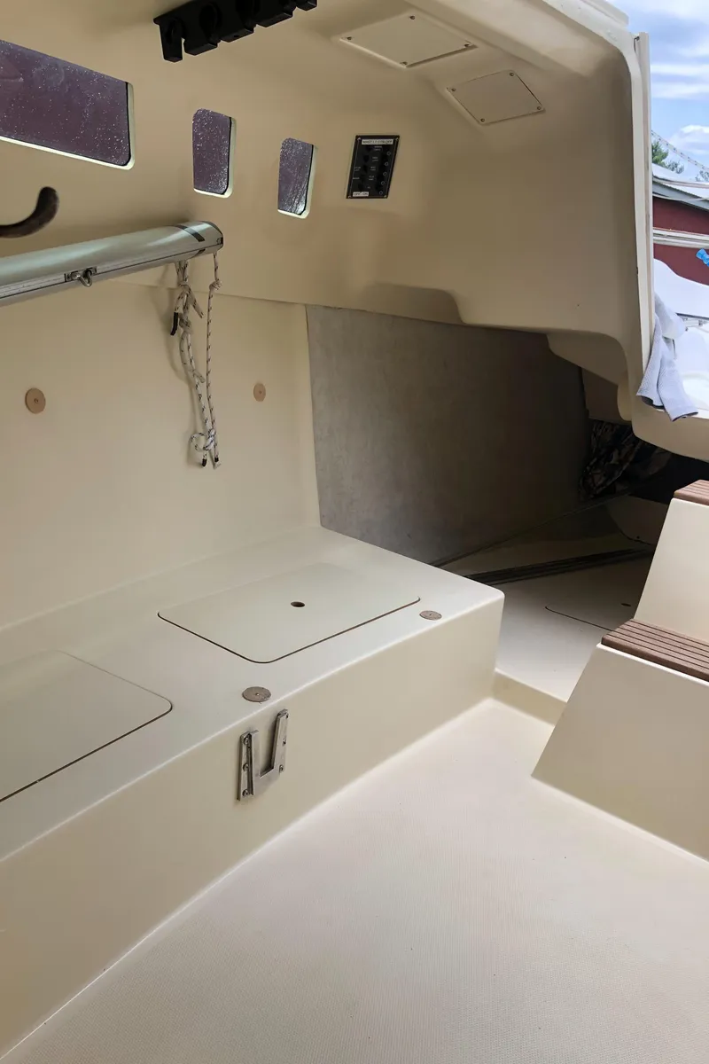 Slide: The Image of Interior of a 1998 Hunter 240 sailboat, featuring seating and storage compartments. - 25