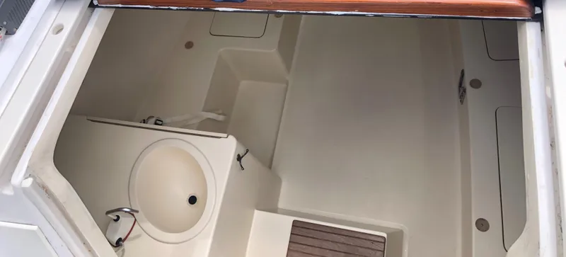 Slide: The Image of Interior of a 1998 Hunter 240 sailboat, featuring a compact sink and storage area. - 26