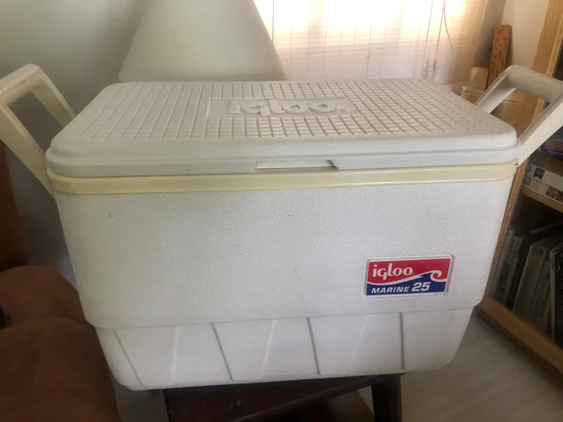 Slide: The Image of White Igloo Marine 25 cooler with handles, indoors on a table. - 32