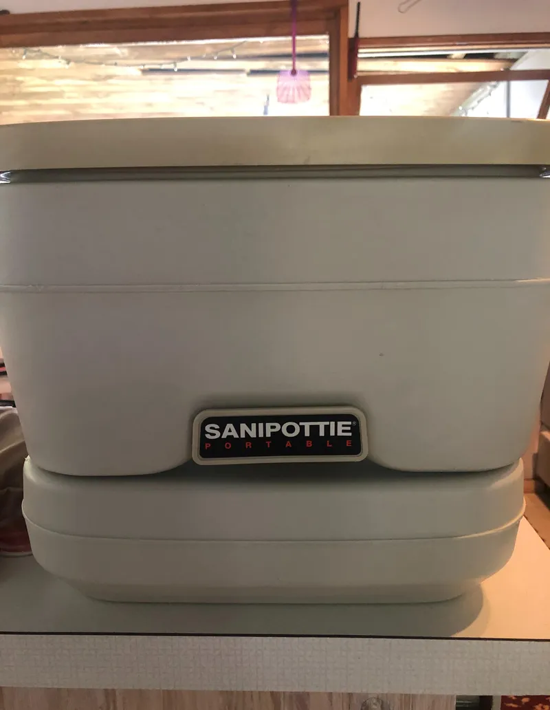 Slide: The Image of Portable toilet labeled "Sanipottie" inside a 1998 Hunter 240 boat. - 33