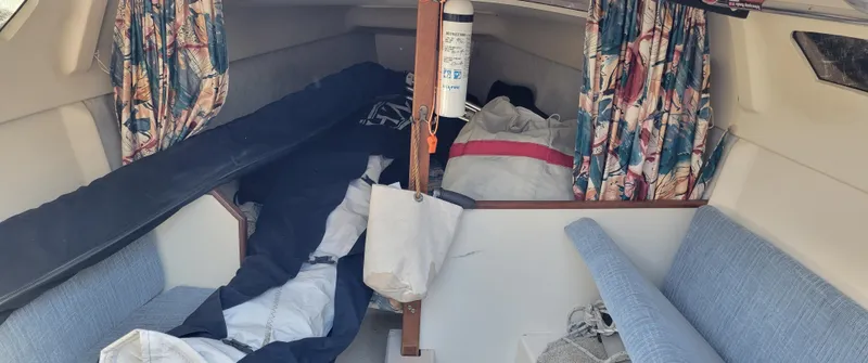 Slide: The Image of Interior of a 1998 Hunter 240 sailboat with colorful curtains and seating. - 6