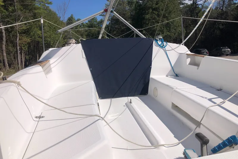 Slide: The Image of 1998 Hunter 240 sailboat deck with ropes and forest background. - 9