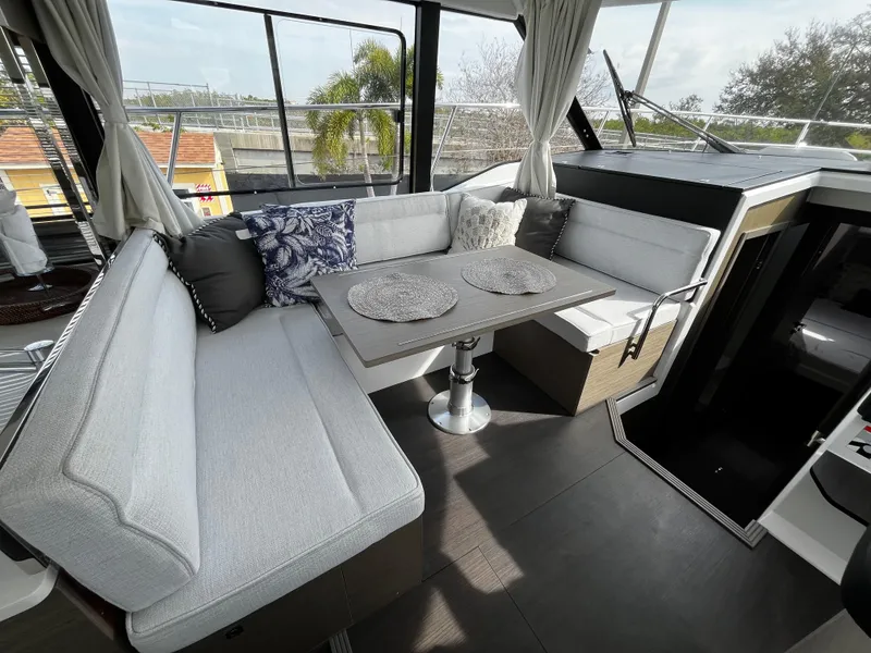 Slide: The Image of Interior seating area of 2024 Jeanneau NC Weekender 1295 Fly with table and cushions. - 15
