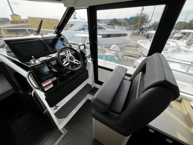 Slide: The Image of 2024 Jeanneau NC Weekender 1295 Fly helm station with modern controls and comfortable seating. - 16