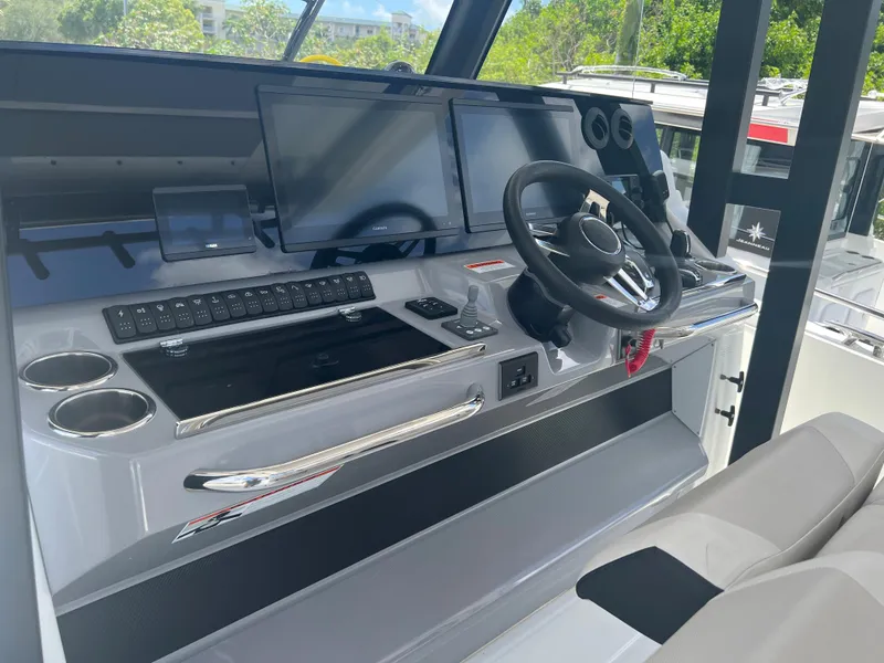 Slide: The Image of 2024 Jeanneau Leader 10.5 CC helm station with modern controls and dual screens. - 16