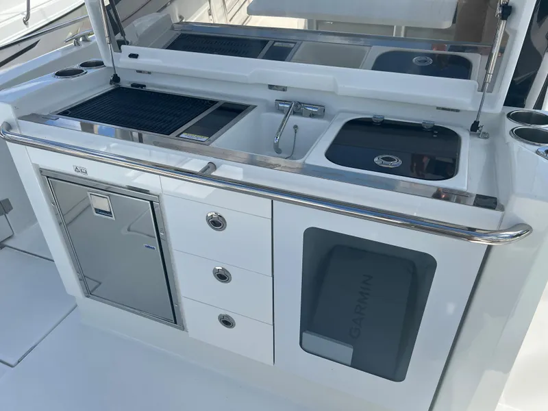 Slide: The Image of 2024 Jeanneau Leader 10.5 CC boat kitchen with sink, stove, and storage. - 17