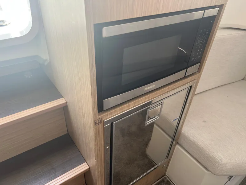 Slide: The Image of 2024 Jeanneau Leader 10.5 CC interior with microwave and mini-fridge. - 19