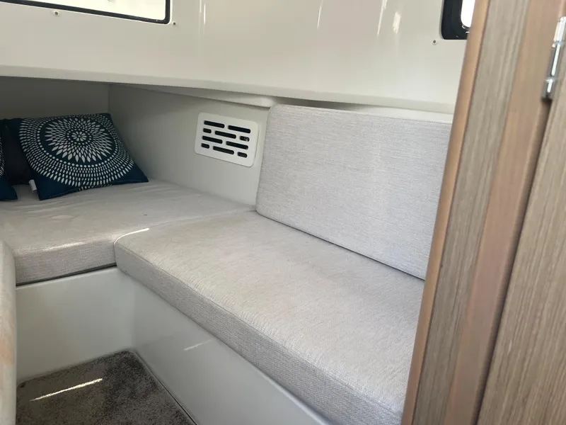 Slide: The Image of 2024 Jeanneau Leader 10.5 CC cabin interior with cushioned seating and decorative pillows. - 22