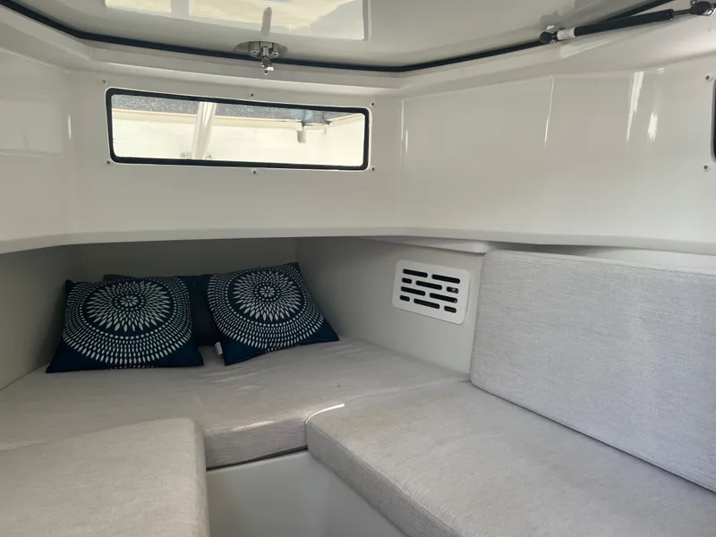 Slide: The Image of 2024 Jeanneau Leader 10.5 CC cabin interior with cushioned seating and decorative pillows. - 24