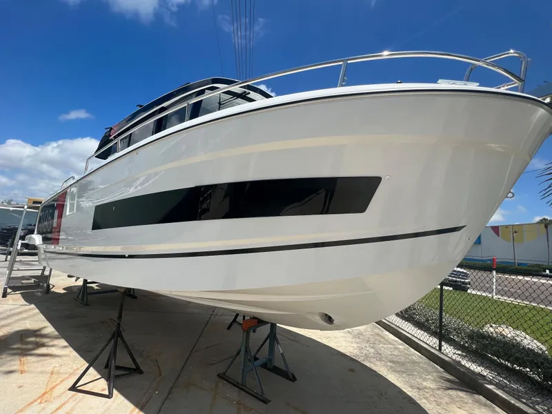 Slide: The Image of 2024 Jeanneau NC Sport 895 boat on stands under a clear blue sky. - 2