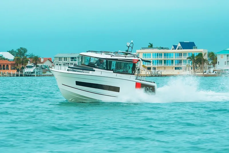 Slide: The Image of 2026 Jeanneau NC Sport 895 cruising on turquoise waters near coastal homes. - 30