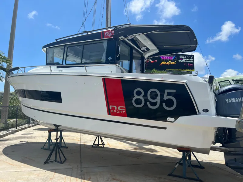 Slide: The Image of 2024 Jeanneau NC Sport 895 boat on stands with Yamaha outboard motor. - 3