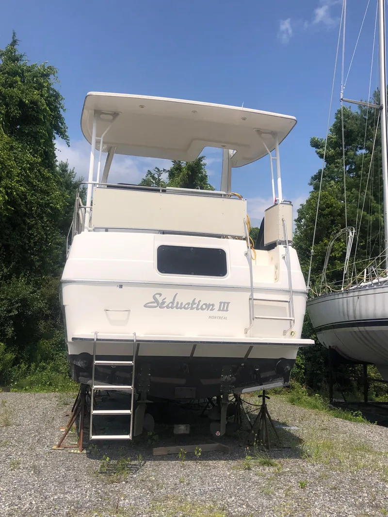The Image of 1996 Bayliner 3587 Motoryacht on land, named "Seduction III," with ladder access. - 1