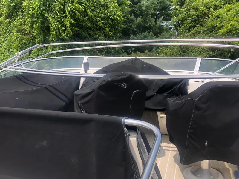 Slide: The Image of 1996 Bayliner 3587 Motoryacht deck with covered seating and lush greenery background. - 13