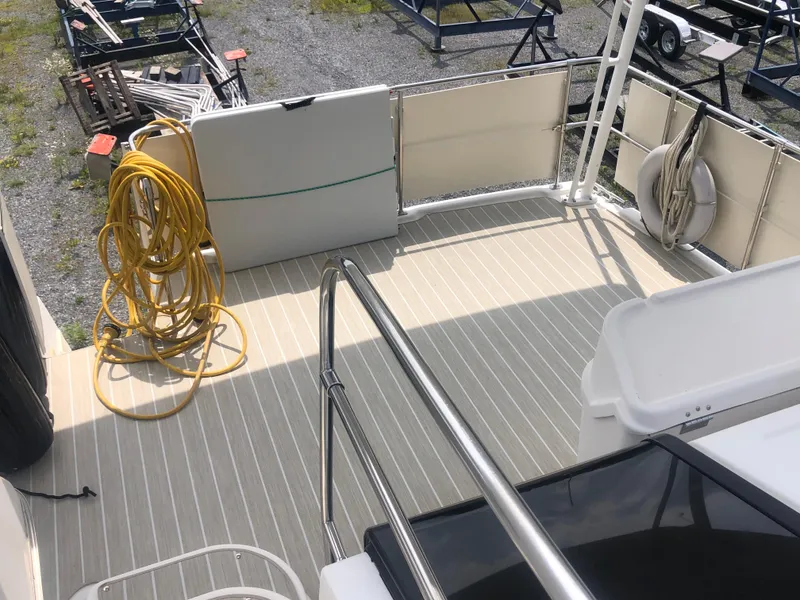 Slide: The Image of 1996 Bayliner 3587 Motoryacht deck with railing, coiled hose, and storage compartments. - 15