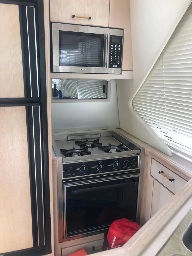 Slide: The Image of 1996 Bayliner 3587 Motoryacht kitchen with stove, microwave, and cabinetry. - 23
