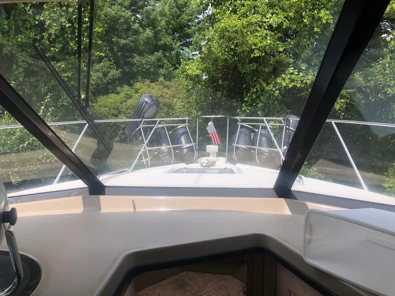 Slide: The Image of 1996 Bayliner 3587 Motoryacht cockpit view with lush greenery in the background. - 25