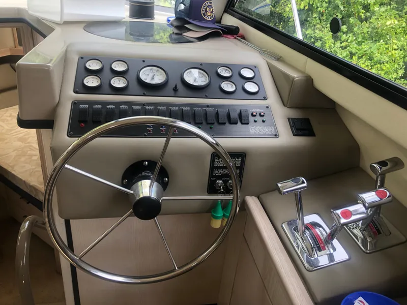 Slide: The Image of 1996 Bayliner 3587 Motoryacht helm with steering wheel, gauges, and throttle controls. - 34