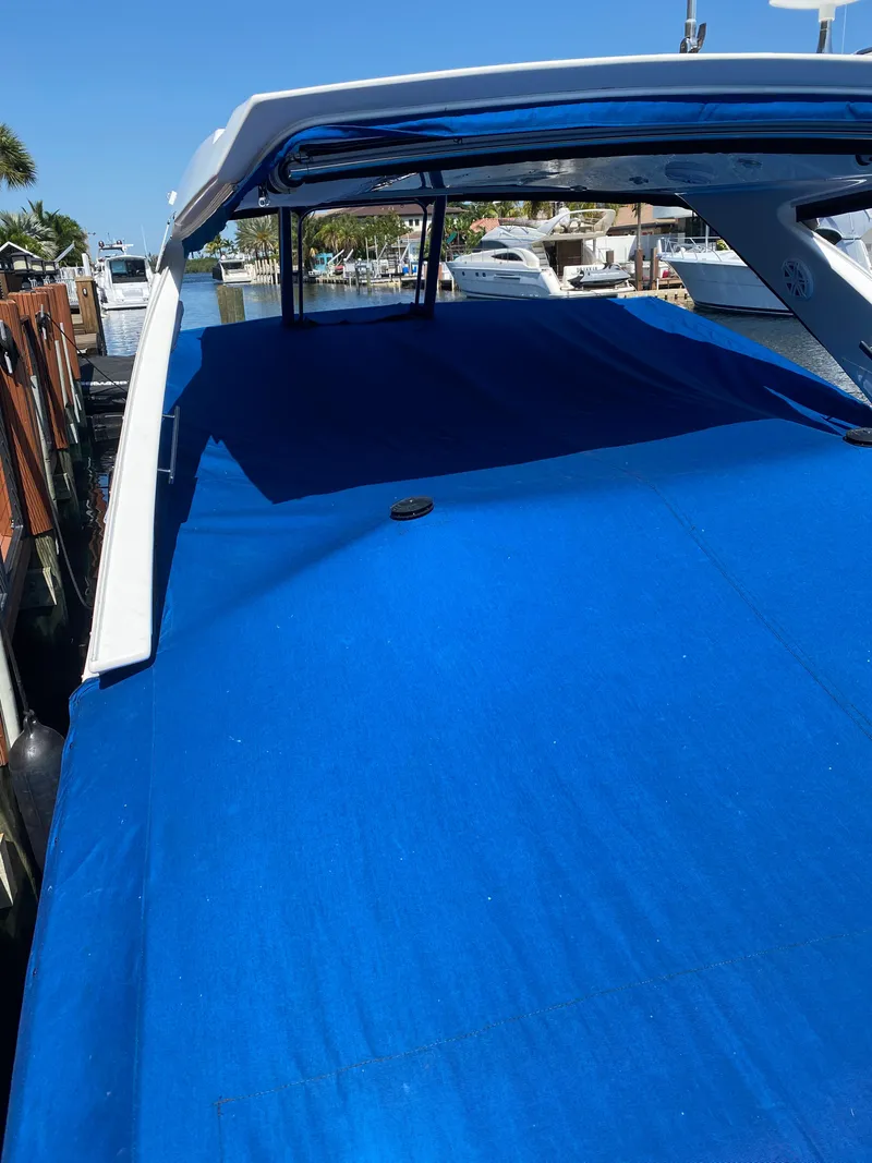 Slide: The Image of 2019 Monterey 378 Super Express boat with blue cover docked at marina. - 18