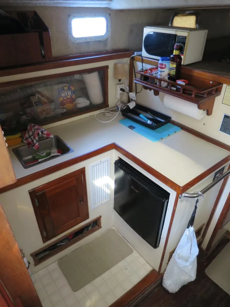 Slide: The Image of Compact kitchen area in a 1999 Eastern 35 boat with sink, fridge, and microwave. - 7