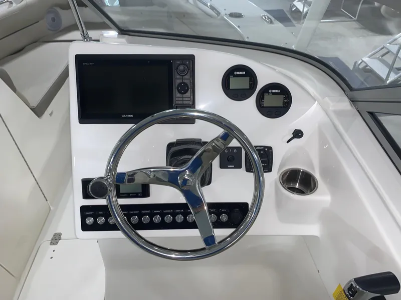 Slide: The Image of 2024 Key West 239 DFS boat dashboard with steering wheel and navigation controls. - 11