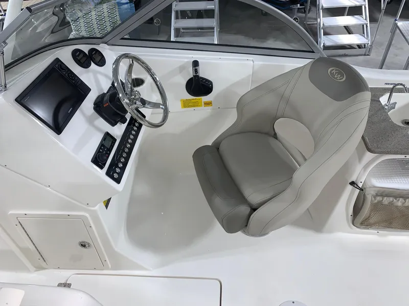 Slide: The Image of 2024 Key West 239 DFS boat cockpit with steering wheel and captain's chair. - 12
