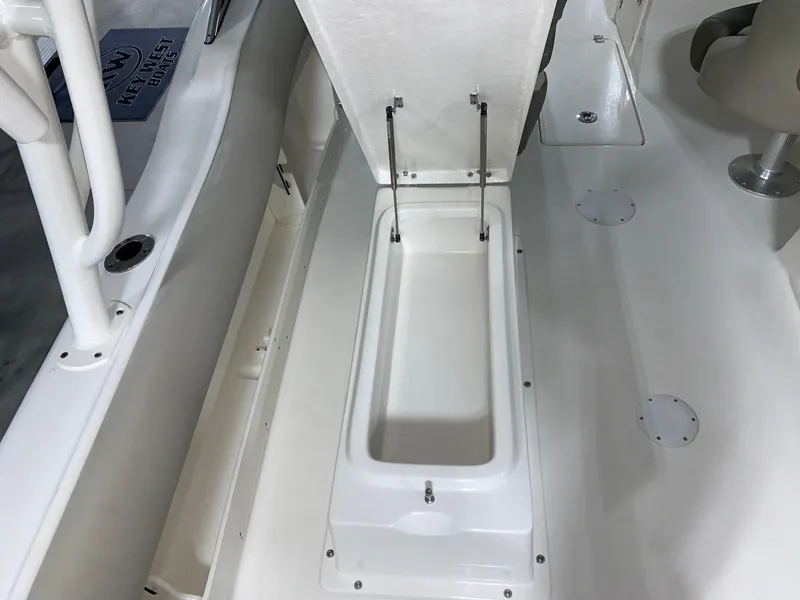 Slide: The Image of 2024 Key West 239 DFS boat storage compartment with open lid. - 17