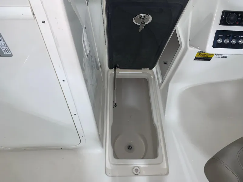 Slide: The Image of 2024 Key West 239 DFS boat storage compartment with open hatch and key. - 9