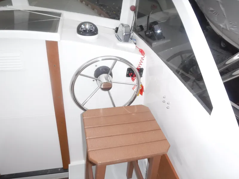 Slide: The Image of Helm station of 1987 Custom Vansant 30 boat with steering wheel and throttle controls. - 25