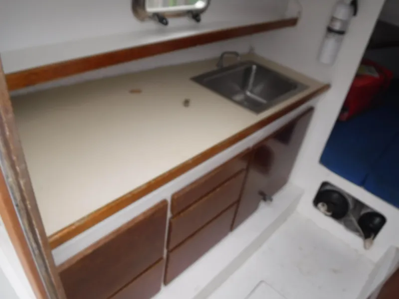Slide: The Image of Compact kitchen area in a 1987 Custom Vansant 30 boat with sink and storage. - 34