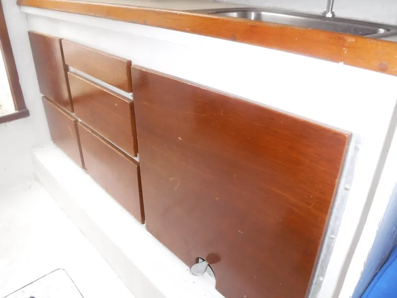 Slide: The Image of Wooden cabinets and drawers in the kitchen area of a 1987 Custom Vansant 30 boat. - 37